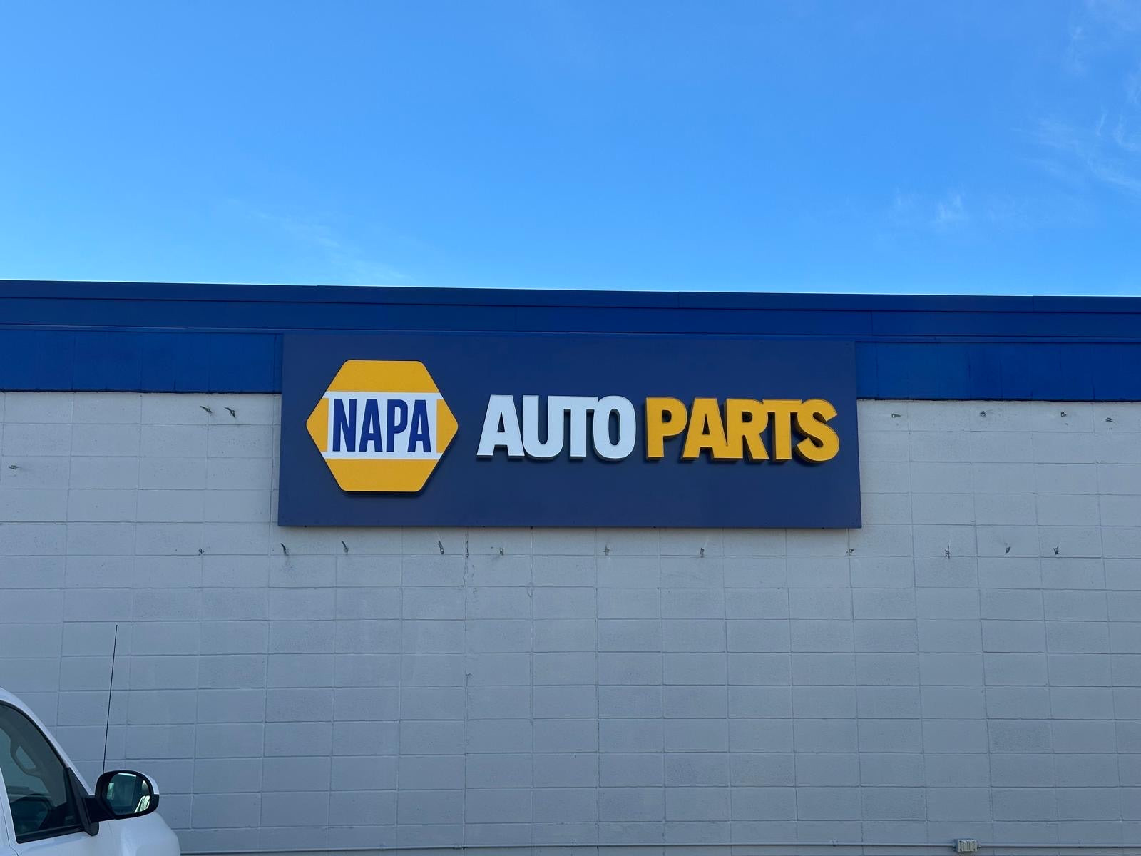 NAPA Auto Parts illuminated building sign at dusk